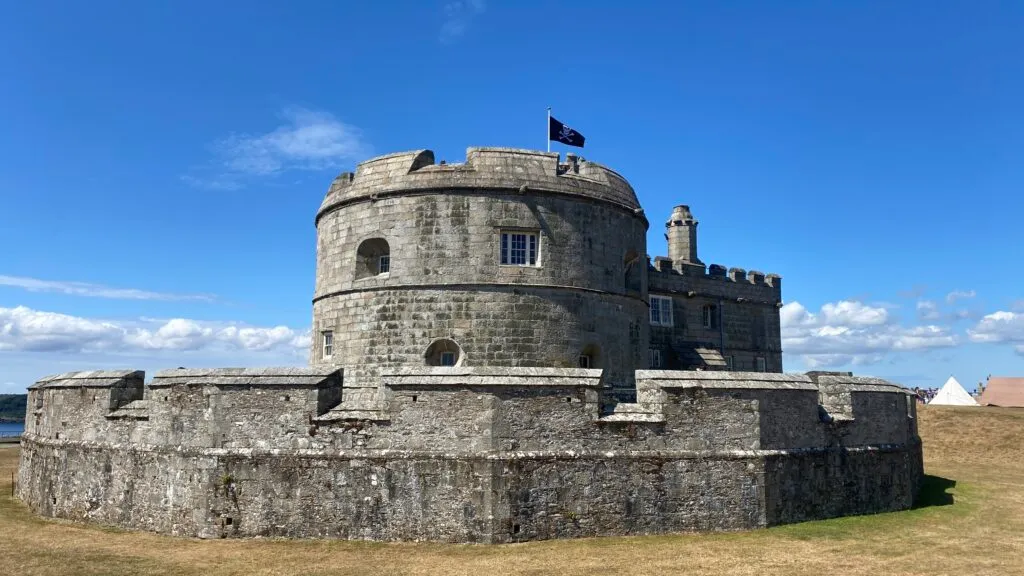 Pendennis Castle on the headland above Falmouth, the Tudor circular keep and granite curtain walls visible against the sky.