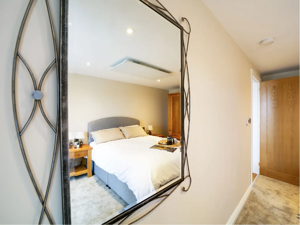 The Tractor Shed bedroom reflected in the ornate mirror in the hallway.
