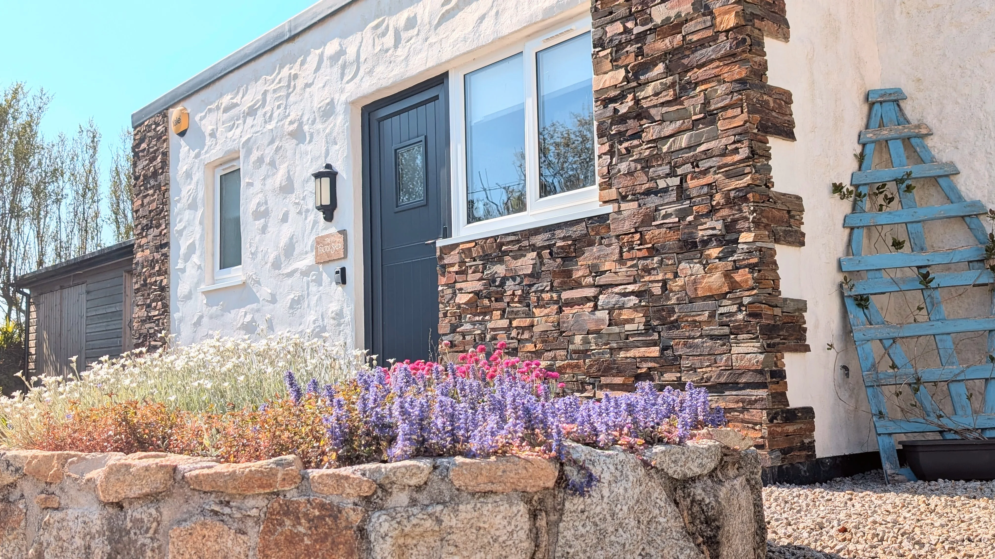 The Tractor Shed exterior, alternative angle, white render with stone detail.