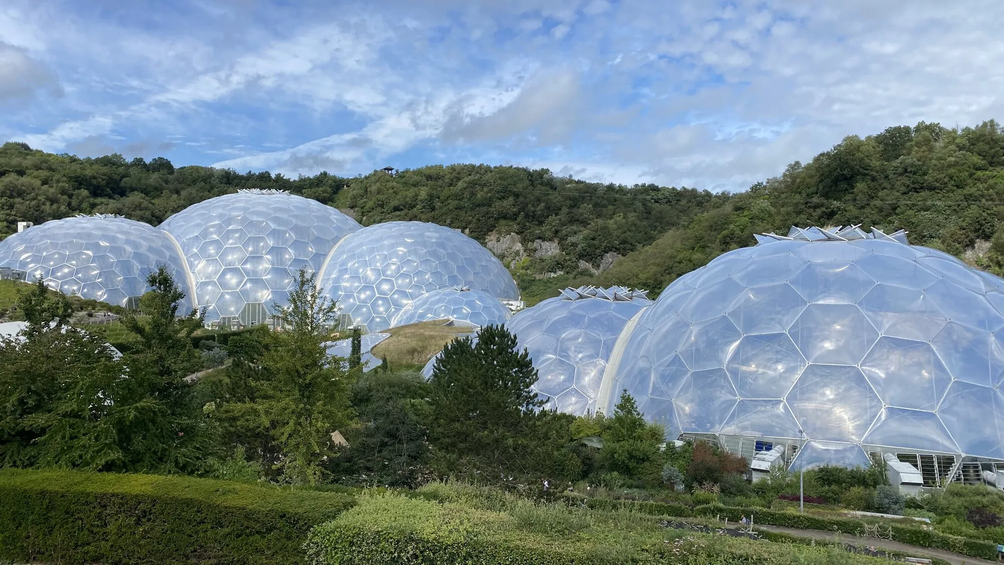 The huge transparent geodesic Biomes of the Eden Project rise out of the green Cornish landscape, set inside a reclaimed china clay pit near St Austell.