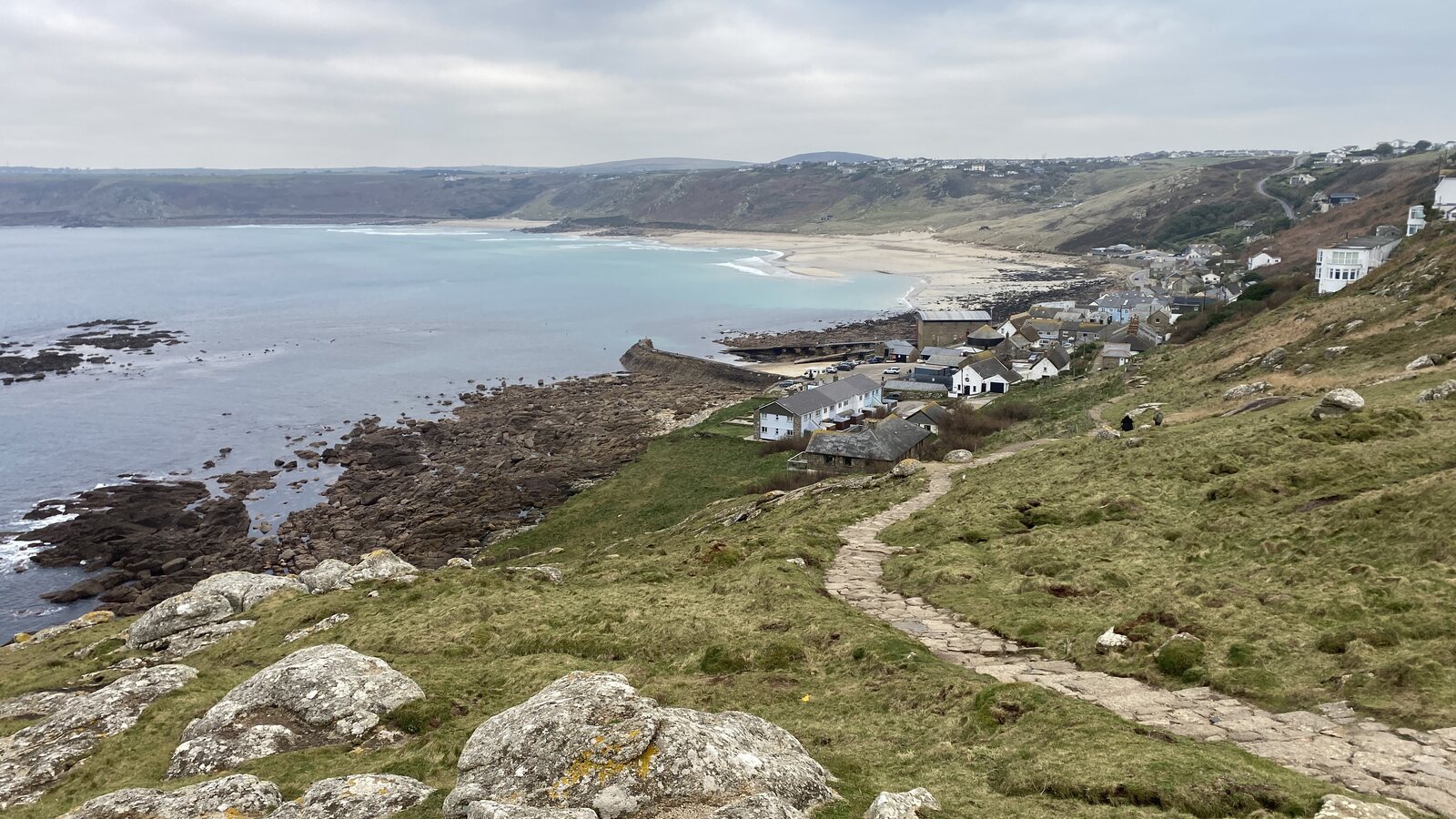 The wild granite cliffs and Atlantic coastline near Sennen Cove on Cornwall's far west, with the South West Coast Path running along the clifftop and views over the open Atlantic.