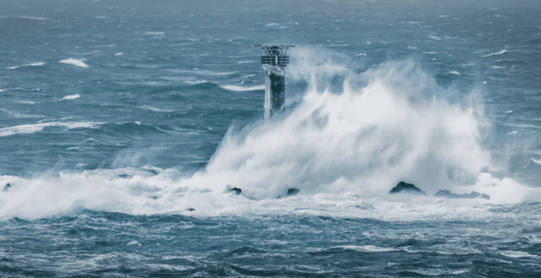 Longships lighthouse near land's end in cornwall gets hit by waves during a winter storm