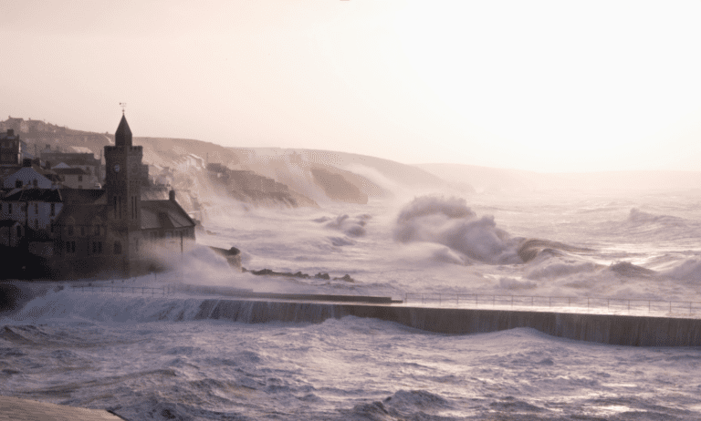 Huge winter storm waves hit Porthleven in Cornwall, the water washes over the harbour and onto the sea wall